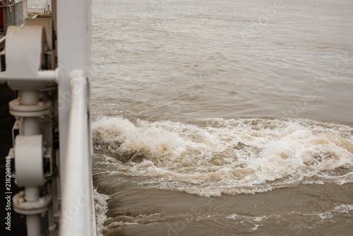 Photography Ship creating powerful wake in muddy river water
