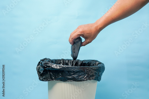 Fotografie Hand discarding computer mouse into trash bin for e-waste recycling or disposal