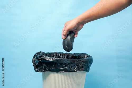 Bild auf Leinwand Hand discarding old computer mouse into trash bin for electronic waste disposal