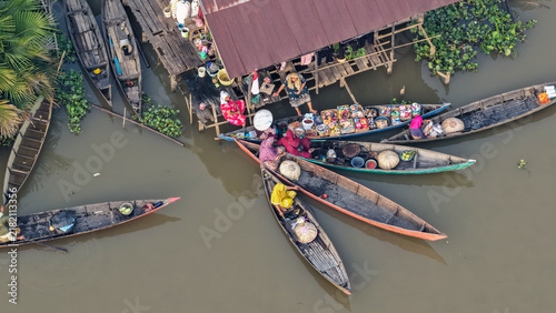 Traders sell goods from small wooden boats at a bustling Banjarmasin river market