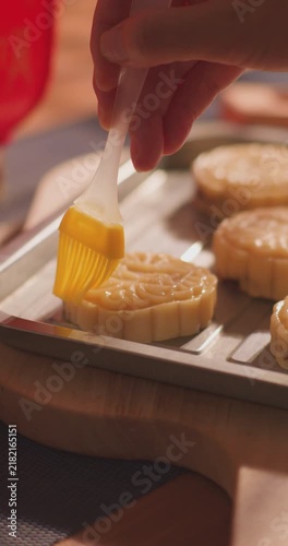 Brushing egg liquid on handmade mooncake for Mid‑Autumn Festival