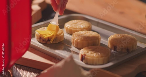 Brushing egg liquid on handmade mooncake for Mid‑Autumn Festival