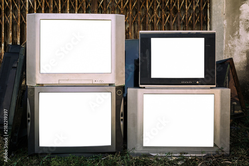 Vintage, old CRT televisions stacked outdoors, with blank white screen, Obsolete electronic devices, e-waste.
