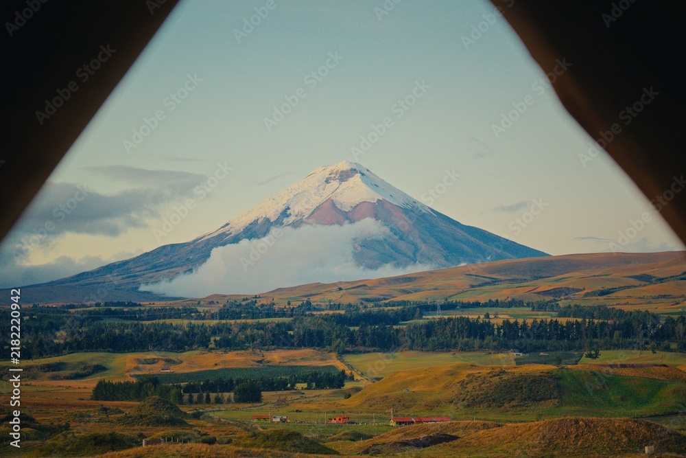 Obraz premium Cotopaxi volcano viewed through triangular frame with rolling hills in Ecuador