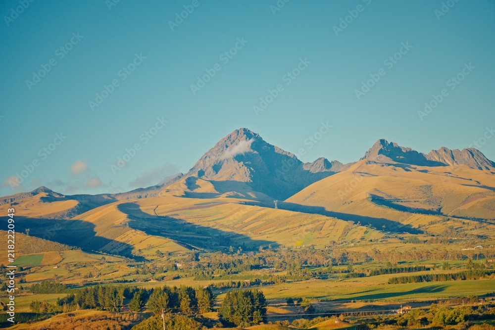 Obraz premium Cotopaxi volcano peak over golden hills in Ecuador