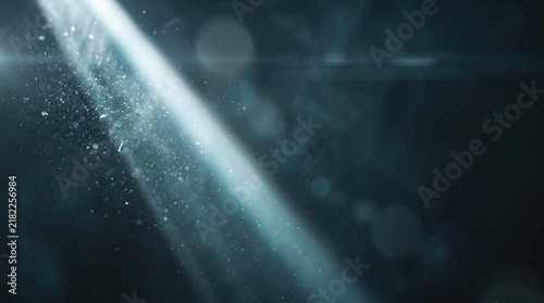 Bright diagonal beam of white light cutting through dark misty atmosphere with floating dust particles and lens flare effects in a deep blue background
