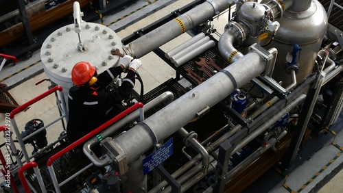 Принти на полотні Maintenance worker with hard hat secures pipe connection on dense refinery equipment, focused and careful in industrial style setting