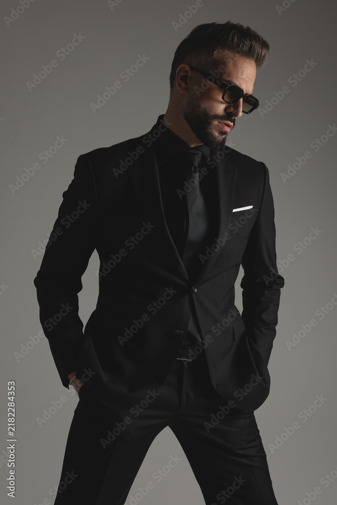 Fototapeta premium Handsome man wearing suit and sunglasses looking to side