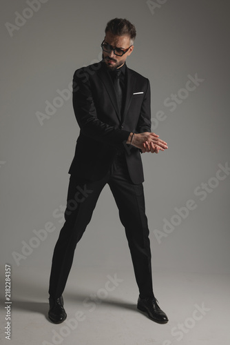 Serious man in suit rubbing hands and looking down