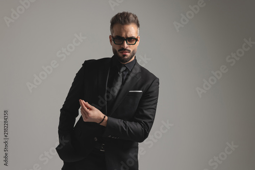 Serious man in black suit gesturing and looking forward