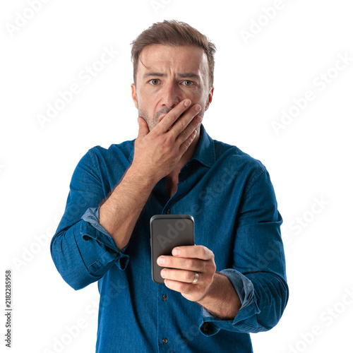 Shocked mature man holding smartphone covering mouth