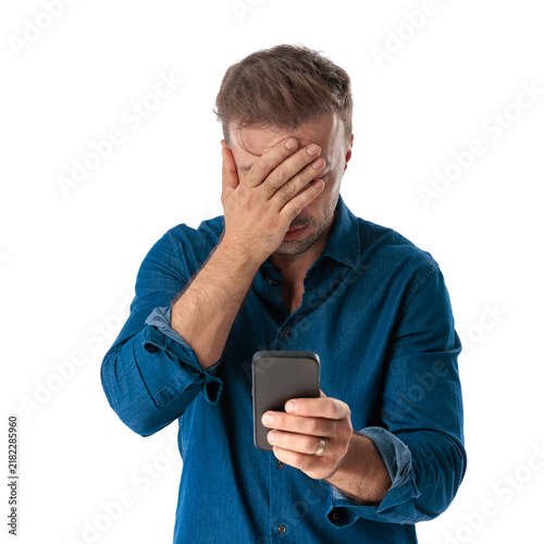 Stressed casual man checking phone