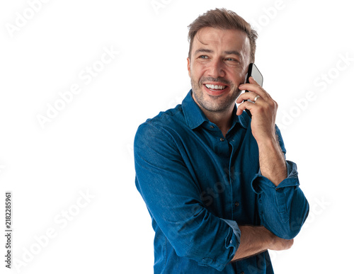 Cheerful middle aged man talking on phone looking side