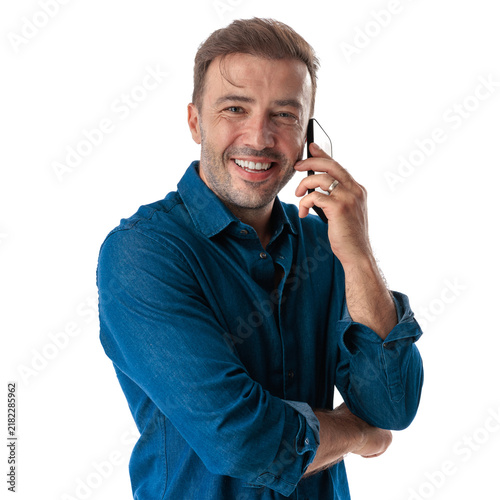 Happy casual man talking on phone looking forward