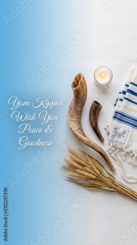 Yom kippur greeting card with shofar horns, prayer shawl, and wheat stalks on a blue and grey background