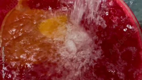 Fresh Water Pouring into a Red Bucket High-Angle View