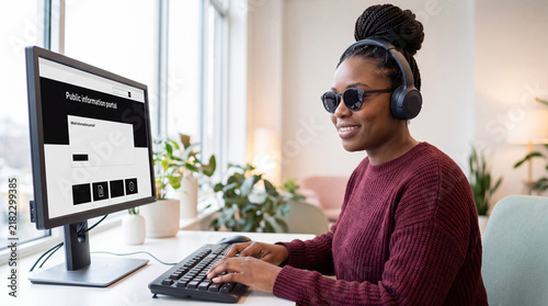 Visually impaired woman using a screen reader for digital public services. Black woman with sunglasses and headphones at a computer. Digital accessibility and inclusive government portal