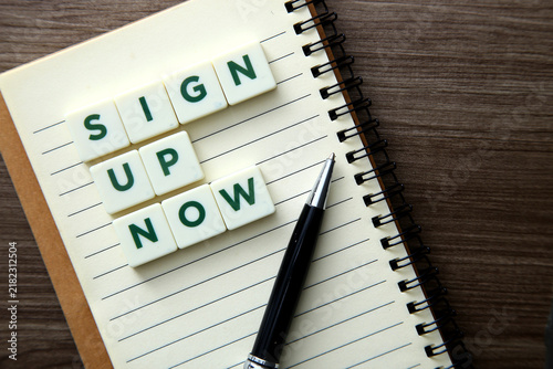 Sign up now message with pen on notebook