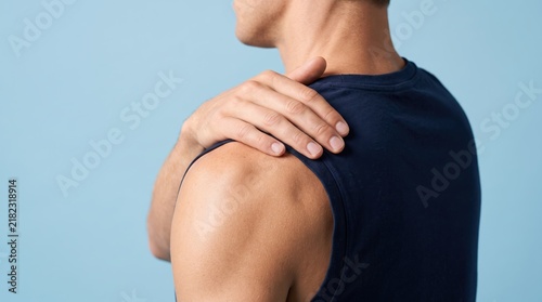 Young athletic man holding shoulder in pain, muscle injury, sports trauma and physical therapy need, upper body discomfort, joint inflammation symptom, physiotherapy treatment