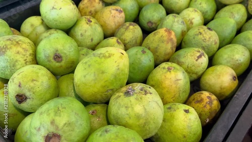 Large pile of fresh green guava fruits in plastic container