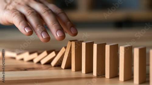 Hand stopping domino effect, symbolizing risk management, crisis prevention, and strategic intervention