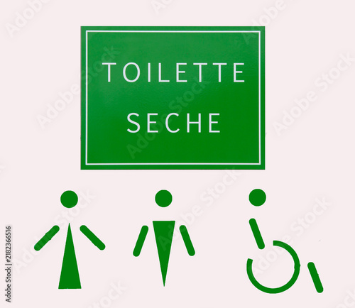 Gros plan sur un panneau indiquant les toilettes sèches pour hommes, femmes et personnes en situation de handicap
