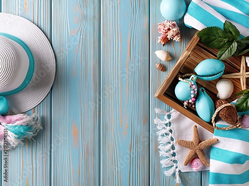 Summer Beach Vacation Accessories Flat Lay Overhead View with Seashells, Starfish, and Sun Hat on Blue Wood