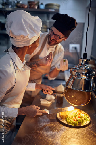 Cook in Professional Modern  kitchen, restaurant concept. happy staff preparing meal.
