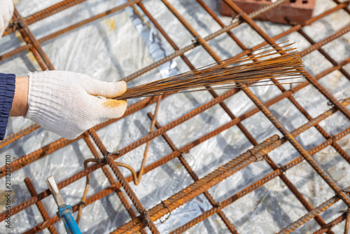 Принти на полотні Construction worker hand in glove holding metal wire for tying rebar mesh