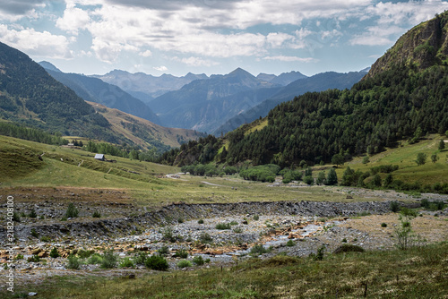 Senderismo por las montañas y valles del Valle de Aran en el Pririneo, caminando junto a un río alpino