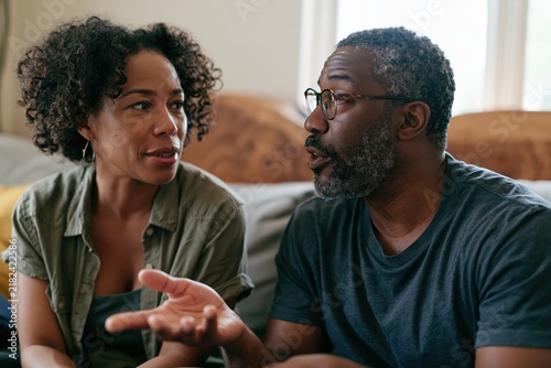 Couple having meaningful conversation on neutral sofa in living room