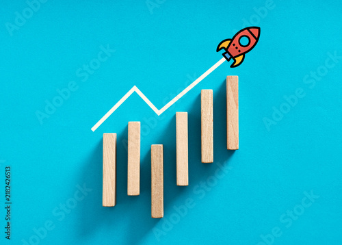 Obraz na płótnie Rising bar chart with a rocket taking off, successful startup, business growth and success
