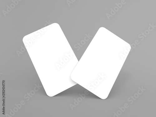 Two blank cards placed at an angle on a gray surface during daylight