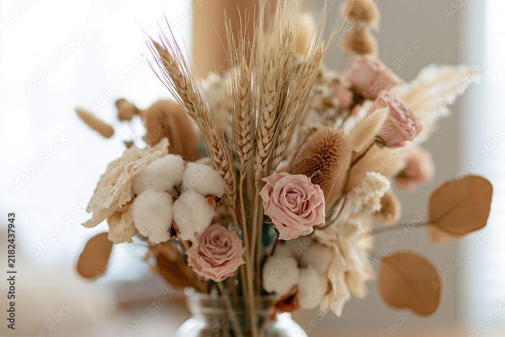 Obraz premium The Dried Cotton and Pink Rose Bouquet in a Glass Vase