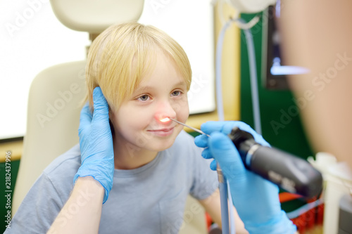 Obraz na plátně A skillful male ENT doctor examines a young patient's nose with an endoscope in a medical office of clinic