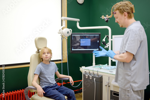 Cuadro en lienzo An experienced otolaryngologist prepares to examine a preteen boy patient in the medical office