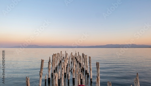 Foto Scenic long exposure view of the weathered wooden poles from a ruined old pier on the peaceful coast of Lake Van during golden sunset