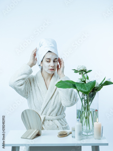 Young Woman with Face Mask and Towel Turban at Vanity Table