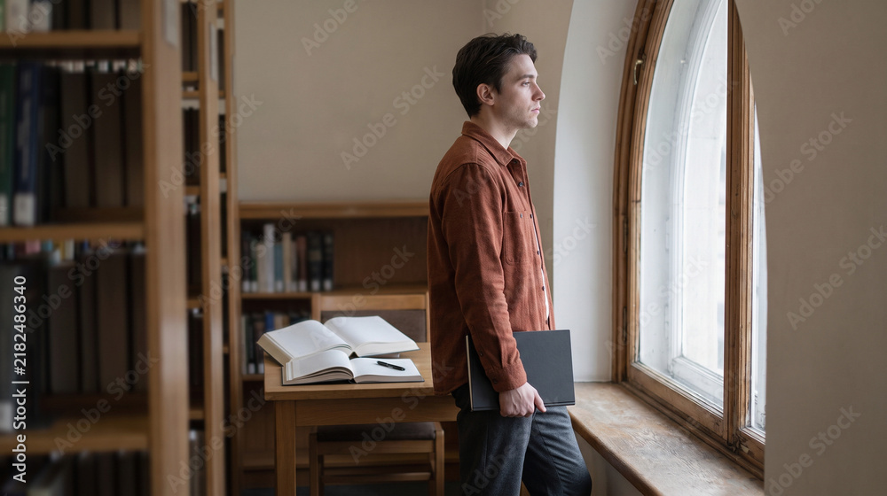 Fototapeta premium Student takes a breather by library study resources