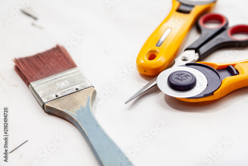 brush scissors and rotary cutter lie on a white surface