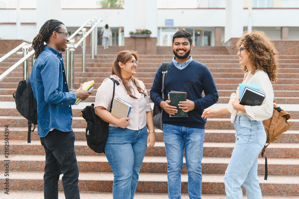 Fototapeta premium Diverse students talking on university campus stairs