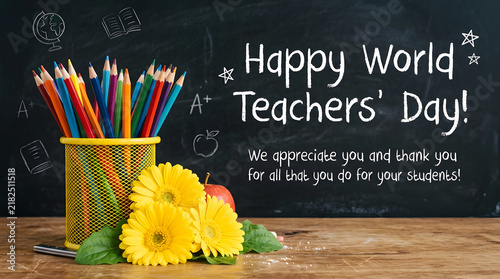 Happy world teachers day greeting card with colorful pencils in holder and yellow flowers on wooden desk