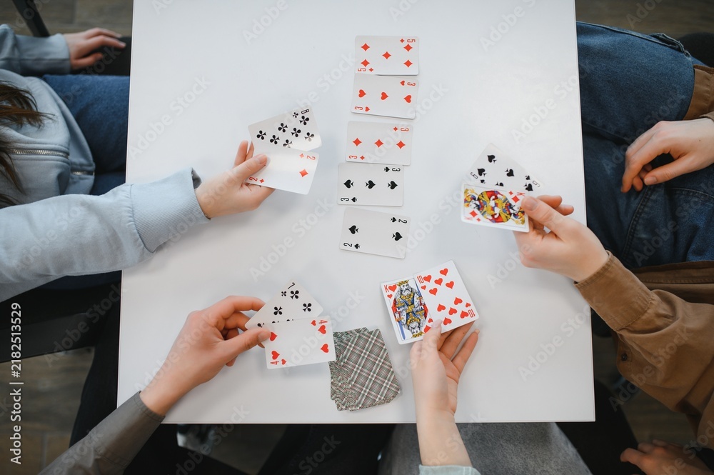 Obraz premium Friends playing cards at home, enjoying their free time
