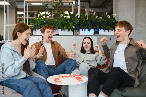 Fotografie Excited young adults playing board game and celebrating victory