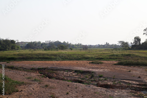 Wide dry cracked earth foreground and distant green landscape in Samboja