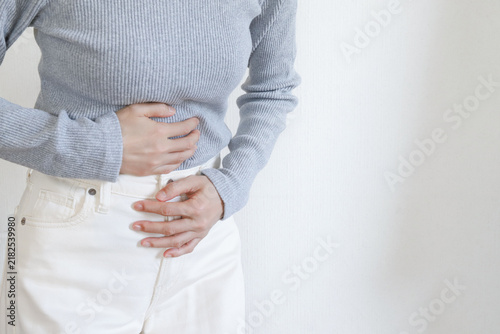 Fotografie お腹を押さえる女性　腹痛