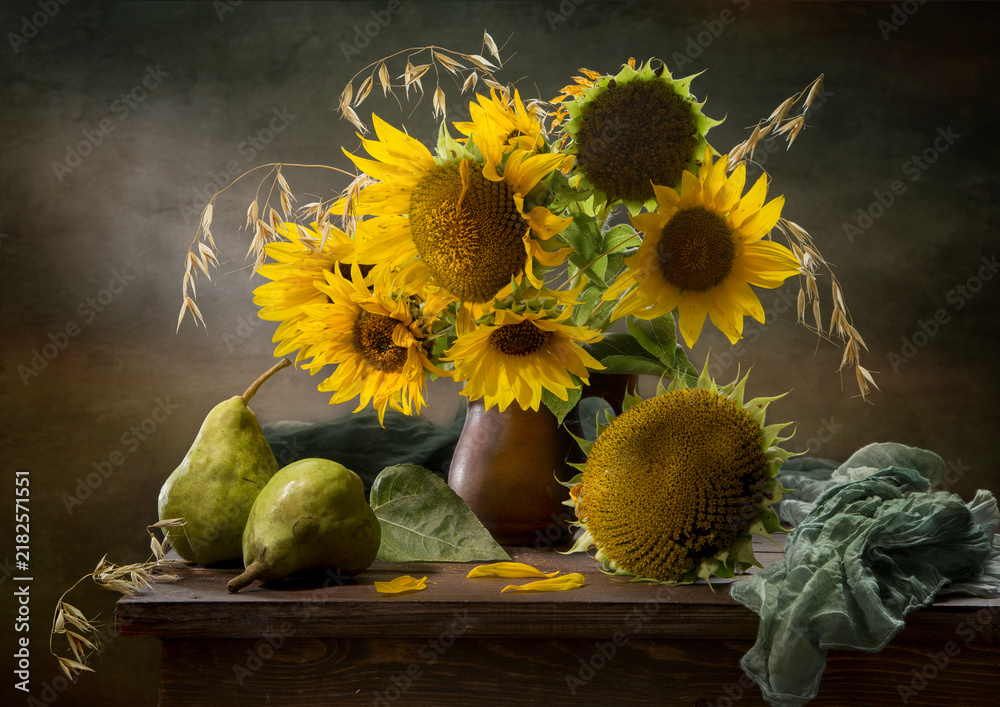 Obraz premium Still life with pears and a bouquet of sunflowers against a dark background