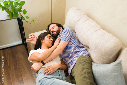 Fotografie Affectionate couple napping together on sofa at home, enjoying a relaxed and com
