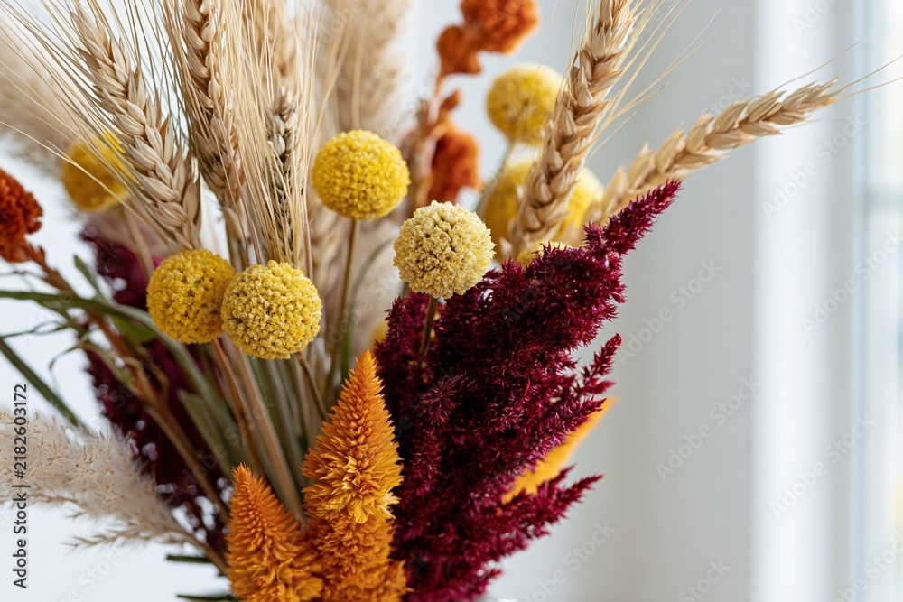 Obraz premium The dried flower bouquet with warm yellow, orange, and burgundy tones.