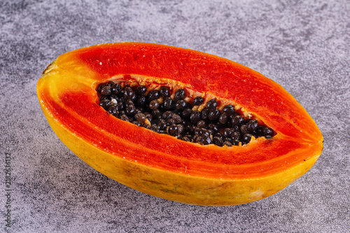 Konstfotografi Freshly cut papaya half displaying vibrant orange flesh and glossy black seeds a